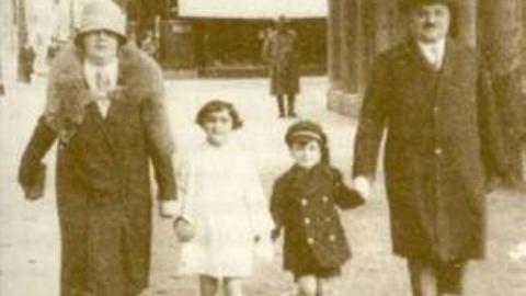 Der Historiker und Publizist Alfred Grosser als Kind mit seinen Eltern und seiner Schwester bei einem Spaziergang in der Neuen Mainzer Straße in Frankfurt auf einem Foto von 1929/1930, im Hintergrund eine Filiale der Reisegepäck-Manufaktur Moritz Mädler
