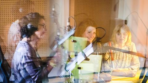 Drei Frauen in einer Kabine für Audio-Deskription im Theater