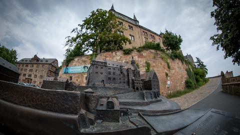 Das Bild zeigt ein Modell des Marburger Landgrafenschlosses in Nahaufnahme. Im Hintergrund ist verschwommen das Landgrafenschloss zu sehen.