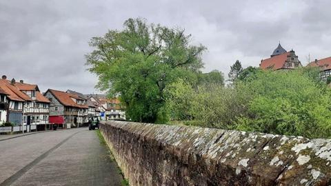 Das Bild zeigt eine Stadtmauer und Fachwerkhäuser. 