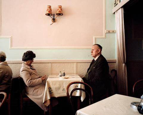 Eine Frau und ein Mann sitzen sich in einem Café gegenüber und starren aneinander vorbei