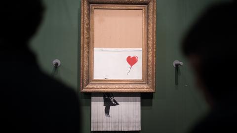 Besucher stehen 2019 vor dem geschredderten Banksy-Bild "Love is in the Bin" in der Staatsgalerie Stuttgart. 
