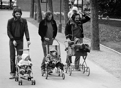 Schwarz-weiß-Fotografie: drei bärtige Männer schieben Kinderwägen