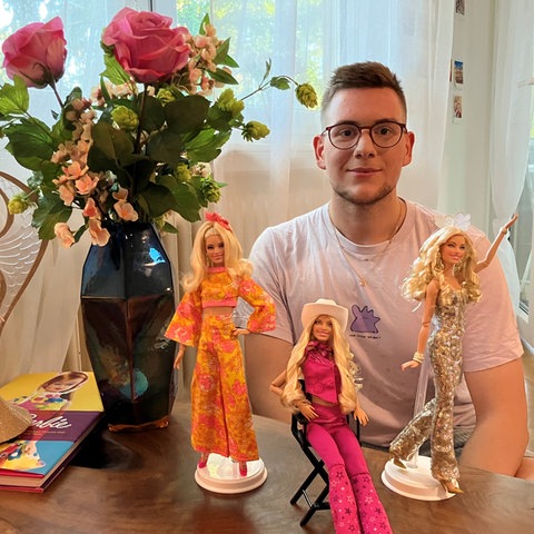 Das Bild zeigt Barbie-Sammler Ricardo mit einigen Barbies
