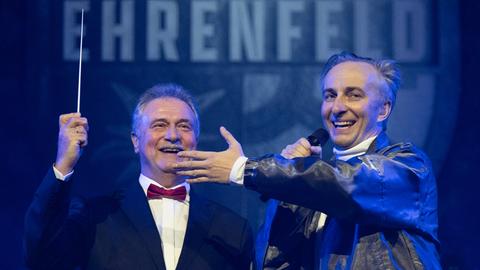 Jan Böhmermann mit Mikrofon und Claus Weselsky mit Taktstock auf der Bühne