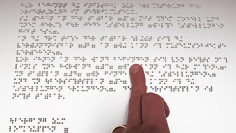 Finger tastet Blindenschrift (Braille) ab