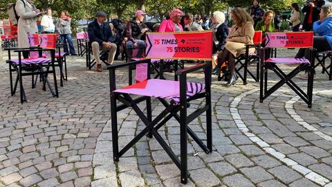 Das Bild zeigt 75 Stühle mit pink-rotem Bezug. Sie wurden zum 75. Jubiläum der Frankfurter Buchmesse aufgebaut und enthalten einen QR-Code, unter dem man Geschichten aus 75 Jahren Buchmesse bekommt.