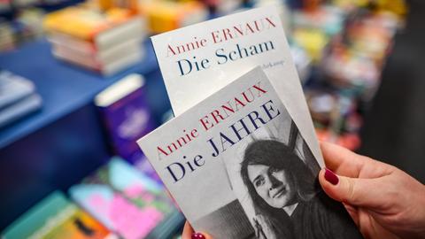 Eine Frau hält zwei Bücher, "Die Scham" und "Die Jahre", von Annie Ernaux in einer Buchhandlung in den Händen.