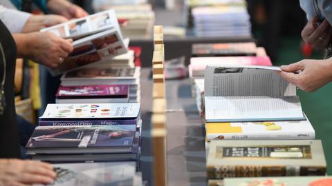 Menschen auf der Buchmesse blättern in Büchern