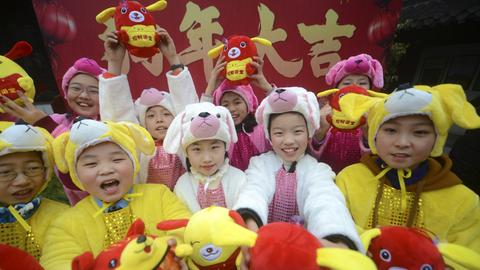 Chinesische Kinder feiern das Neujahrsfest verkleidet
