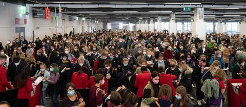 Publikumsmasse beim Einlass zur Buchmesse. Blick in die Hallem aus der Vogelperspektive fotografiert.