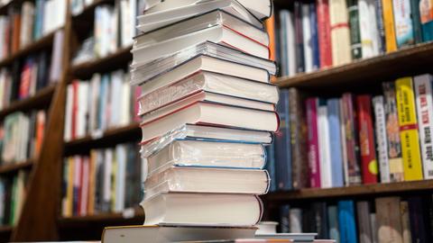 Ein Stapel neuer Bücher liegt auf einem Verkaufstisch in einer Buchhandlung im Frankfurter Stadtteil Bornheim.