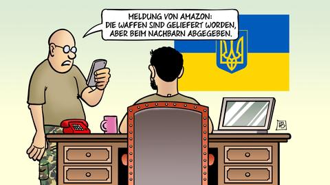 Karikatur: Zwei Männer an einem Schreibtisch unter der ukrainischen Flagge, einer liest von seinem Smartphone vor.