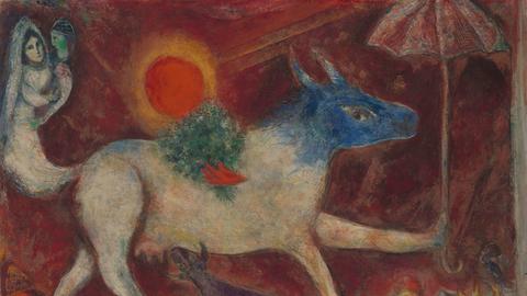 Das Chagall-Gemälde "Die Kuh mit dem Sonnenschirm" zeigt eine Kuh mit blauem Kopf und einem Bund Blumen auf dem Rücken. Sie hält einen roten Schirm in der Vorderhufe. Im Bild zu sehens ind außerdem eine in weiß gekleidete Frau mit Schleier sowie eine Art Hund.