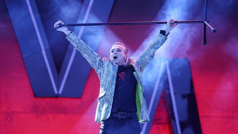 Dave Gahan, der Leadsänger von Depeche Mode, hält einen Mikrofonständer quer über Kopf