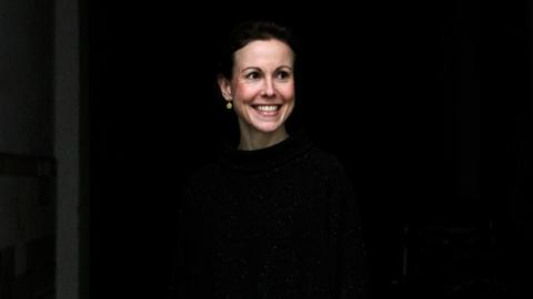 Jeanne Diesteldorf steht lächelnd vor einem schwarzen Hintergrund