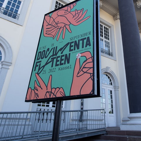 documenta-Plakat in einem Plakatständer vor Säulen des Eingangbereichs des Museums "Fridericianum" (Froschperspektive). 