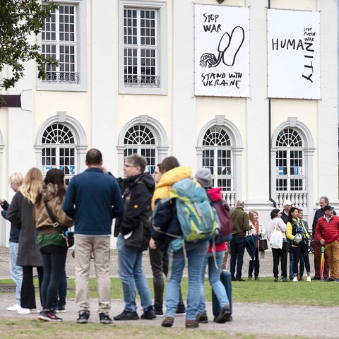 Besucherschlange vor dem Ausstellungsort Fridericianum, an dessen Außenwand Kunstwerke zu sehen sind.