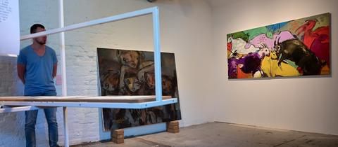 Gemälde von Raouf Al Ajouri (li., "Behind the wall") und Mohammed Al Hawajri (re., "Animals") in der Ausstellung von Künstlern aus dem Gazastreifen