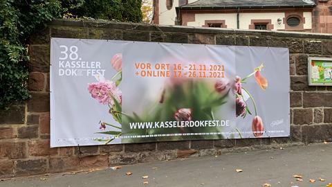 Ein Plakat mit der Aufschrift "38. Kasseler Dokfest" hängt an einer Mauer.