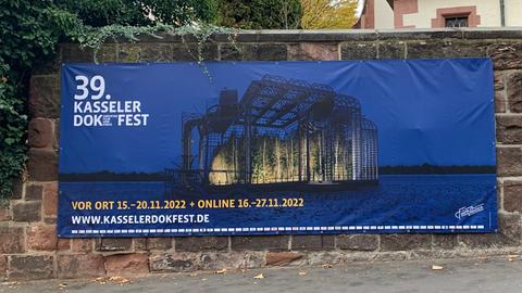 Ein Banner vom Kasseler Docfilmfest hängt an einer Mauer