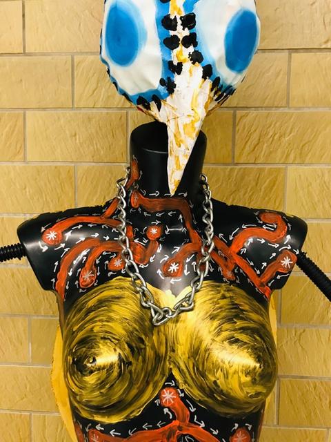 Auf den Torso einer schwarzen Schaufensterpuppe ist ein Vogelkopf gesetzt. Der Torso ist gold bemalt.
