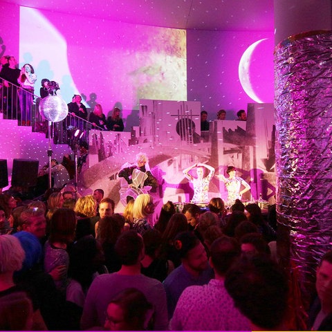 Bildkombination aus zwei Fotos: links ein Foto einer Performance im Museum mit vielen Menschen in violettem Licht; rechts Yogafiguren vor einem Bild im Museum