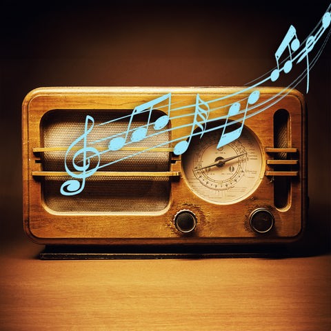 Ein Holz-Radio steht auf einem Holtisch, Musik ertönt. 
