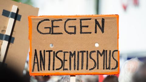 Demonstranten halten ein Schild hoch: "Gegen Antisemitismus"