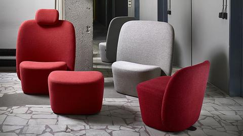 Sessel in rot und grau stehen in einem Industrieambiente