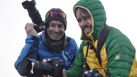 Zwei Männer in Winterkleidung mit Kameras