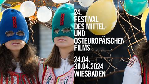 Zwei junge Frauen mit gestrickten Sturmhauben und bunt bestickten Blusen, Schrift: "24. goEast – Festival des mittel- und osteuropäischen Films (24. April bis 30. April 2024)"