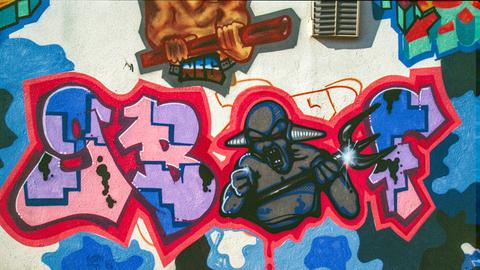Graffito mit den Buchstaben GBF, dazwischen eine Gestalt mit Hörnern und Dreizack in der Hand