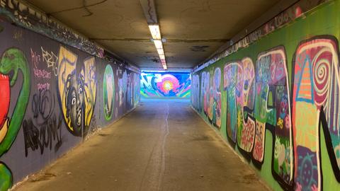 Rechts und Links sind farbige Graffiti zu sehen: Blick in die Tunnelröhren unter dem HoPla in Kassel