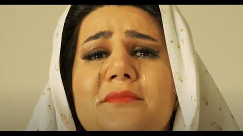 Das Bild zeigt einen Screenshot Screenshot aus einem Musikvideo von Hafen der Zuflucht-Stipendiatin Sahar Ajdamsani. Darauf zu sehen ist eine Frau mit Hijab, dunklen Haaren und roten Lippen, der Tränen das Gesicht herunterlaufen.
