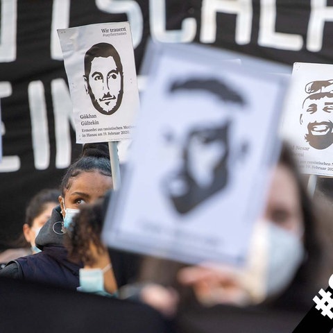 Demo-Teilnehmer halten Schilder mit den Portraits der Opfer des Anschlags hoch.