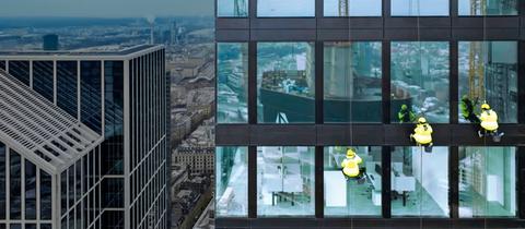 Drei Menschen in gelben Schutzjacken hängen an Seilen an der Glasfassade eines Hochhauses, im Hintergrund die Stadt.