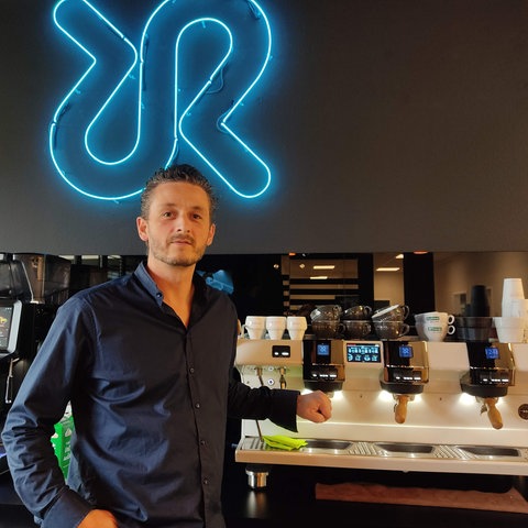 Barista Patrice Wiedemann vor einer High-Tech-Espresso-Anlage