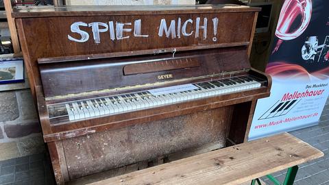 Klavier von Ahrweiler im Feuerwehrmuseum Fulda - mit getrocknetem Schlamm bedecktes Klavier - mit weißer Farbe steht darauf SPIEL MICH!