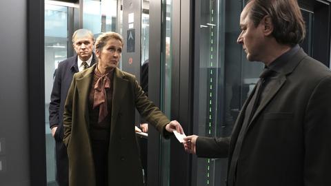 Kommissar und Assistentin steigen in einen Fahrstuhl im Hotel