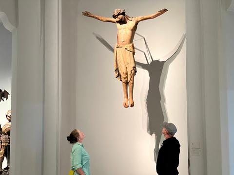 Mann und Frau vor hängender Jesusfigur