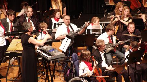 Orchestre, certains musiciens sont visiblement handicapés.