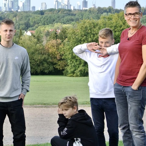Zwei Frauen mit drei Halbwüchsigen Söhnen vor der Frankfurter Skyline
