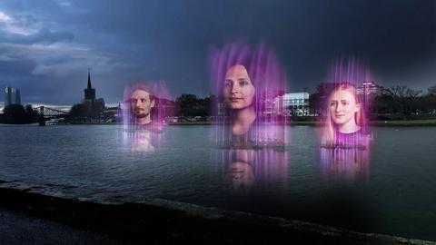 Digitalisierte Gesichter schweben über der Wasseroberfläche am Frankfurter Mainufer.