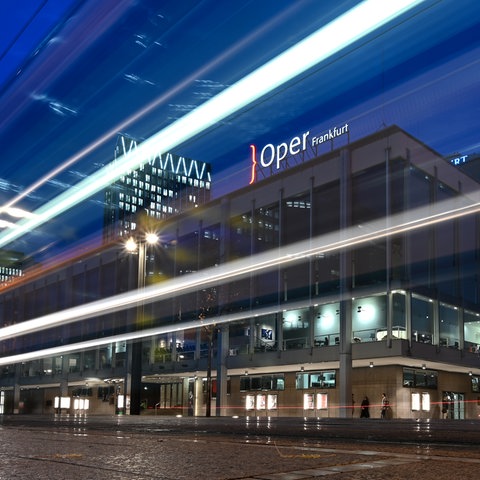 Lichtspuren einer vorbeifahrenden Straßenbahn sind am Abend vor Oper und Schauspiel zu sehen (Aufnahme mit Langzeitbelichtung). 