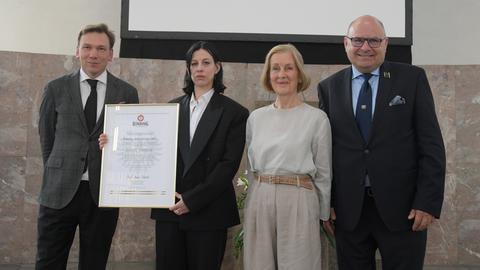 Anne Imhof hält die Urkunde über den Binding-Kulturpreis in der Hand.