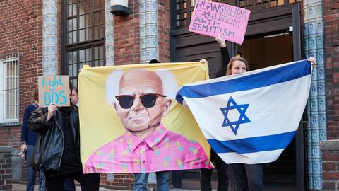 Protestierende halten vor dem Eingang der Hochschule für bildende Künste Hamburg (HfbK) Tranparente mit der Aufschrift "Ruangrupa C$sh From Anti-semitism", "Fight BDS", eine Israelfahne und ein Konterfei von David Ben-Gurion, ehemaliger Premierminister von Israel, hoch. 