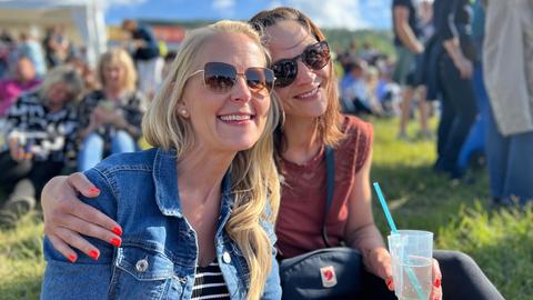 Zwei Frauen sitzen auf der Wiese beim Roland Kaiser-Open-Air