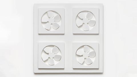 Künstlerische Arbeit an einer weißen Wand. Vier kleine, weiße Ventilatoren gruppieren sich im Viereck auf einer quadratischen Fläche.