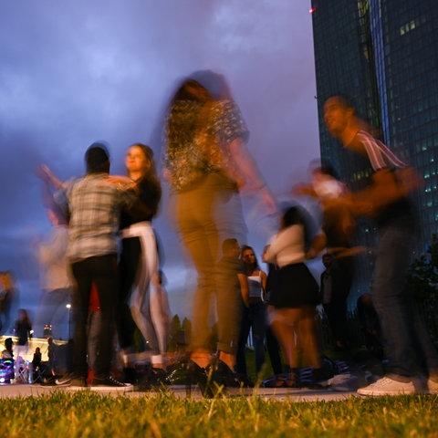 Tänzer in der Abend-Dämmerung, im Hintergrund das Hochhaus der EZB.